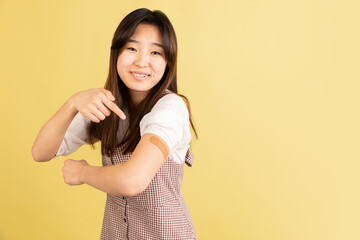 Obraz premium Asian young woman's portrait on yellow studio background. Concept of human emotions, facial expression, youth, sales, ad.