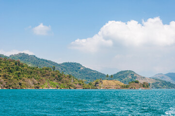 Fototapeta premium Coastline scenic view with blue sky and sea. Summer vacation day at Paraty's sea.