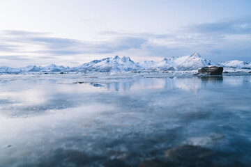 Snowy mountainous valley with frozen sea