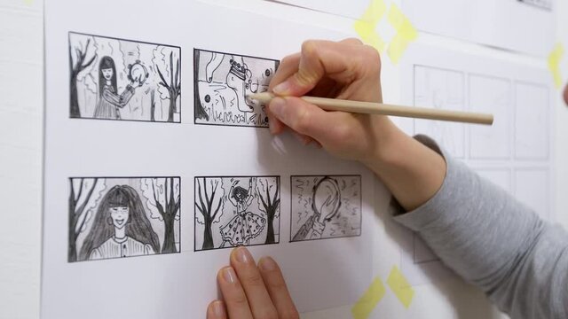 A designer draws a storyboard for an animated film comic strip. Scene sketches for the cartoon. 4K.