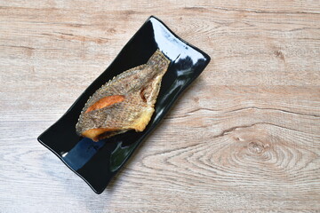 deep fried snake skin catfish or gourami on black dish
