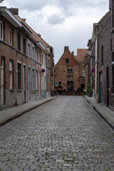 picturesque historic brick buildings typical of the old city center of Bruges with a horse and carriage in the background