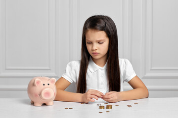 Obraz na płótnie Canvas Little child girl with piggy bank at home