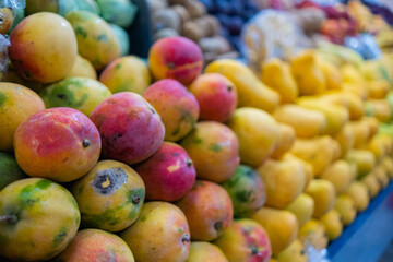 Close-up of a colorful fruit stand with fresh mangoes