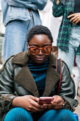 Portrait of woman with sunglasses and afro using her phone