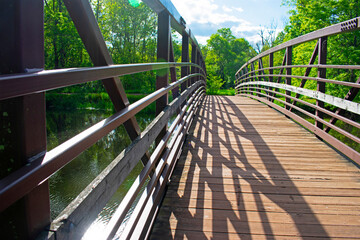 Steel pedestrian footbridge with wooden walkway crossing a narrow section of the Delaware and Raritan Canal at Colonial Park, Franklin Township, New Jersey. -10