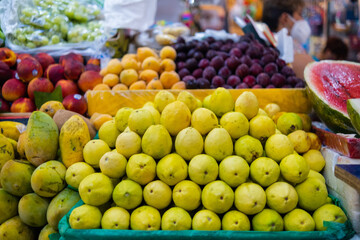Colorful fruit stand with guavas, mangoes, peaches, and more