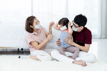 Obraz na płótnie Canvas Asian parents wear masks for daughters with developmental disabilities. Before preparing to leave the house to prevent PM2.5 and Covid-19 dust, medical commentary.