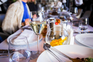 Glassware, glasses for white wine on a table in the restaurant. Banquet, cutlery, table setting. 