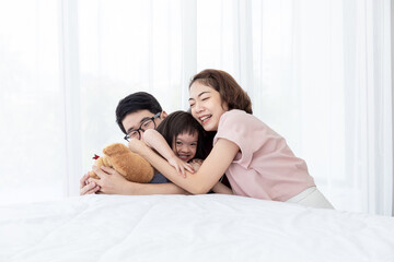 Disabled girl with a cerebral palsy syndrome, studying, laughing, playing, parents in white bedroom playing with their daughter happy and smiling. Happy hugging Happy education concept.