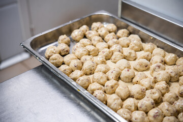 A tray with the dough of the typical Spanish croquettes with ham, prepared for frying, in the kitchen of a restaurant. Spanish croquettes