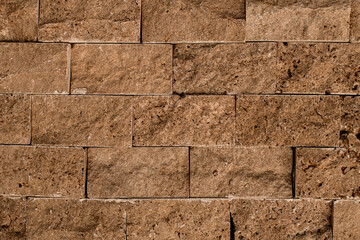 Close-up of texture of masonry of brown square stone block.