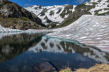 Lac au printemps en cours de dégel , Paysage des Alpes Grées au printemps , Col du Petit Saint-Bernard , Italie	