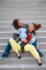 funny young couple sitting on steps and playing with chewing gum