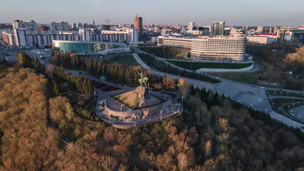 Obraz premium Beautiful and colorful cityscape. Monument to the rider on a horse. Trees. Sunlight at sunset.