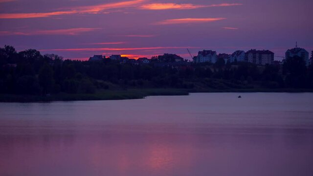 Beautiful 4k time lapse with sunset over small lake near city.