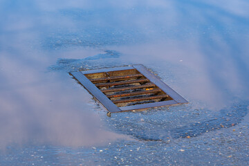 Clogged stormwater and puddle of water after rain