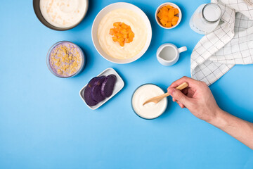 Flatlay of different flavors of yoghurt on blue background