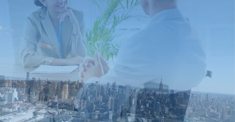 Composition of midsection of businessman and smiling businesswoman in meeting over modern cityscape