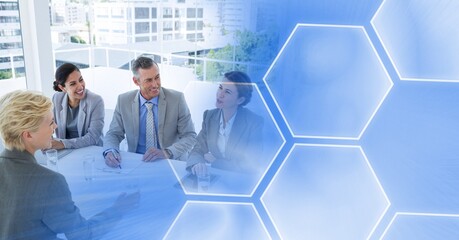 Composition of smiling male and female business colleagues with blue hexagon overlay