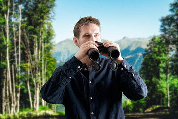 young person hiking in the mountains and using binoculars, travel concept