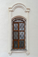 Fototapeta na wymiar A window with a beautiful grille in the old Orthodox church. Outdoors, building fasade front view.