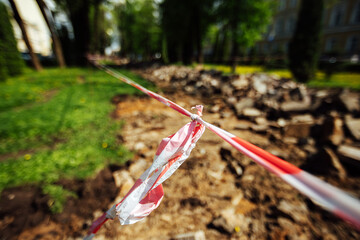 a warning ribbon prohibits passage. cordon tape around the dangerous place. repair work at the site of the asphalt failure after the disaster. cordon around the quarantine zone