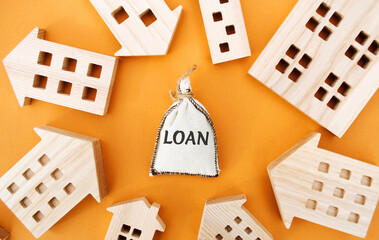 Money bag with the word Loan and wooden houses around. The concept of mortgage housing and real...