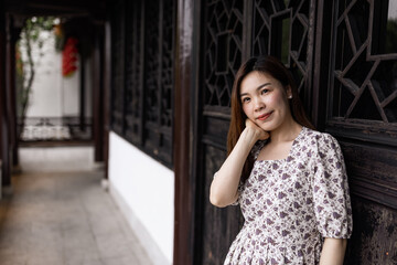Fototapeta premium Portrait of young asian woman wearing stylish summer dress and walking outdoor in old city. Happy stylish woman with smiley face enjoys life