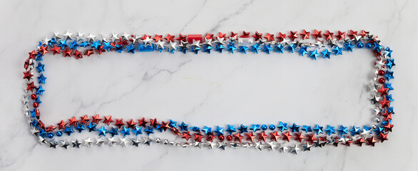 American Independence Day red blue white stars beads frame on on Marble Background. USA flag colors...