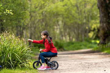 big girl riding little bike in the forest
