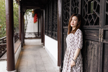 Portrait of young asian woman wearing stylish summer dress and walking outdoor in old city. Happy stylish woman with smiley face enjoys life