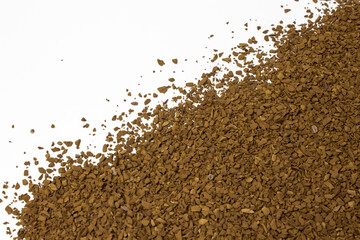 granules of brown aromatic instant coffee on a white background diagonally. Place for text,...