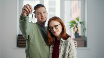 The guy holds a bunch of keys in front of the camera and hugs his girlfriend