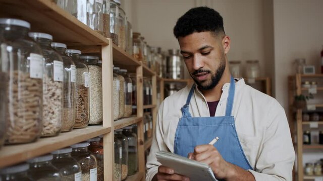 Male owner of zero waste shop doing audit.