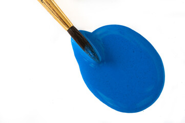 Blue acrylic paint with paintbrush dipped in