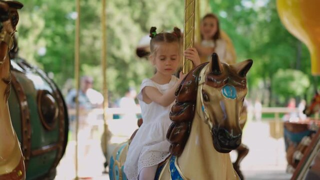 Little girl ride Horse Old Fashioned French Carousel, Roundabout. Handheld Handshake effect High quality 4k footage
