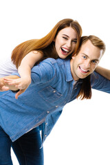 Portrait image of expressive amorous funny laughing couple. Standing piggy back ride models in love studio concept, on white background. Man and woman posing together.