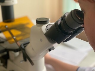 Scientists are conducting research under a microscope.