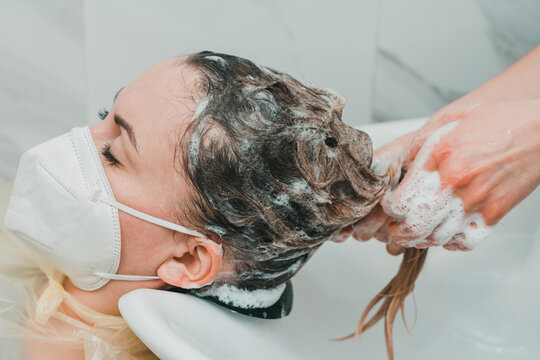 Washing the head in the barbershop, hair care, the hairdresser washes the client's head.