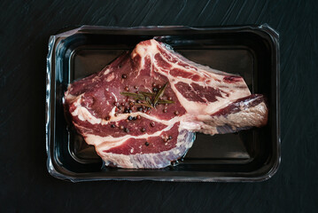 Raw beef steak and spices vacuum Packed on dark background. Top view. airtight packaging. Vacuum-packed meat