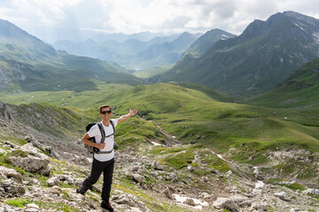 Naklejka premium Young hiker walking with the wonderful panorama of the swiss alps in the background