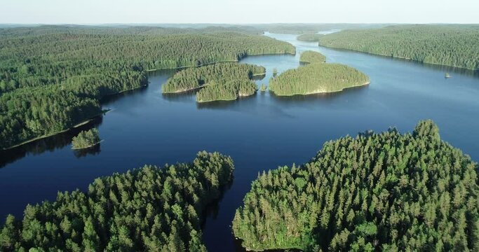 Aerial view of beautiful blue lake, islands and green summer forest. Blue sky. Top view. Popular tourist attraction. Exploration travel world.