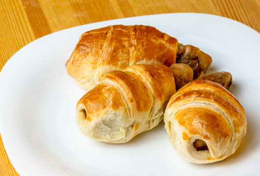 Appetizing Chicken Legs In Puff Pastry On A White Plate And Wooden Background