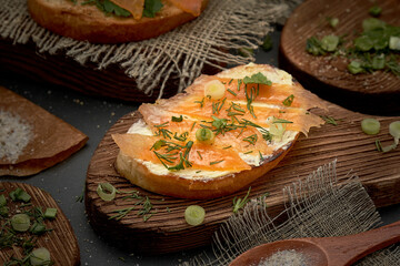 Butter and trout sandwich on a wooden Board. Diet Breakfast sandwich with red fish and greens.