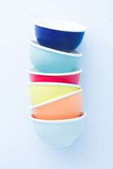 Colored bowl  orange ,yellow pink ,blue and green color flatlay, over a blue wallpaper type background, top view, flatlay