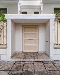 contemporary house front entrance white door by the sidewalk