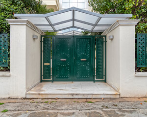 contemporary house front entrance gate with glass cover and double green metal door