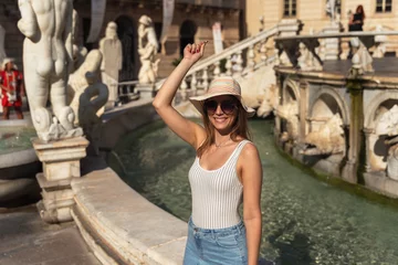 Fotobehang young woman throwing a coin in an Italian fountain in Sicily © NDStock