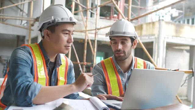 Engineering team working at building site meeting and discussing on laptop . Team onsite of architecture inspector and discuss together